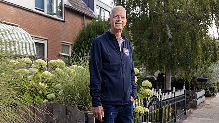 Op de foto staat een man met grijs haar.