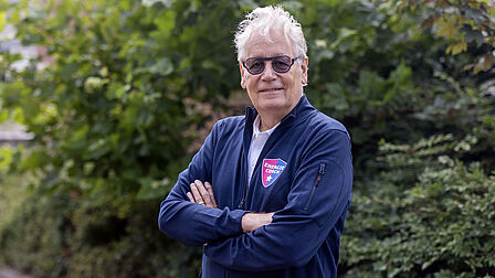 Op de foto staat een man met grijs haar.