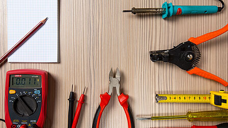 Op tafel liggen allerlei gereedschappen: van tangen tot een kladblok