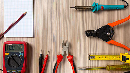 Op tafel liggen allerlei gereedschappen: van tangen tot een kladblok